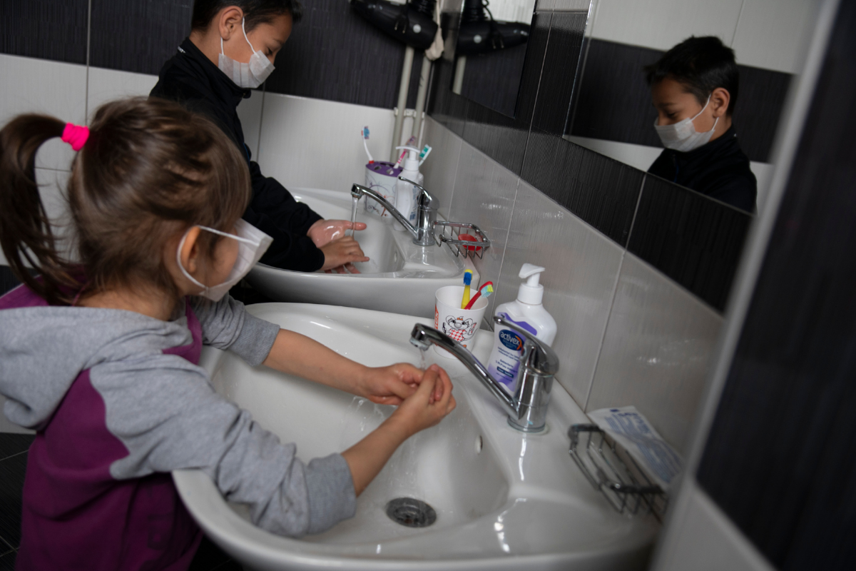 Children washing hands and wearing masks during COVID-19