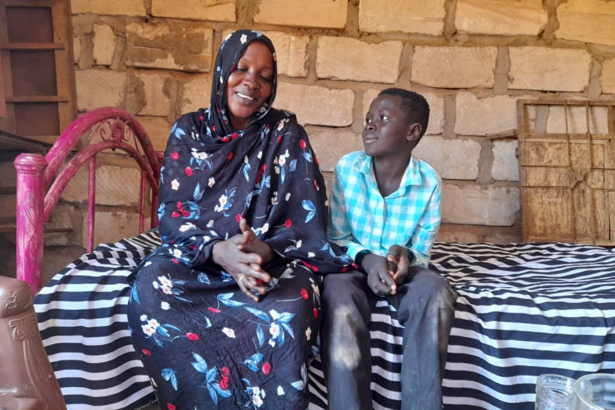 Awadiya from Sudan poses with one of her seven children
